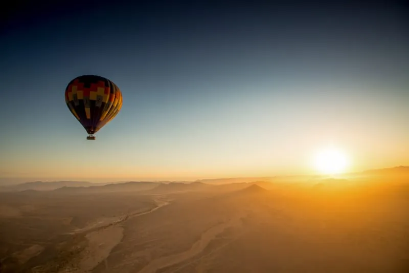 A hot air balloon drifting over the Namib at sunrise