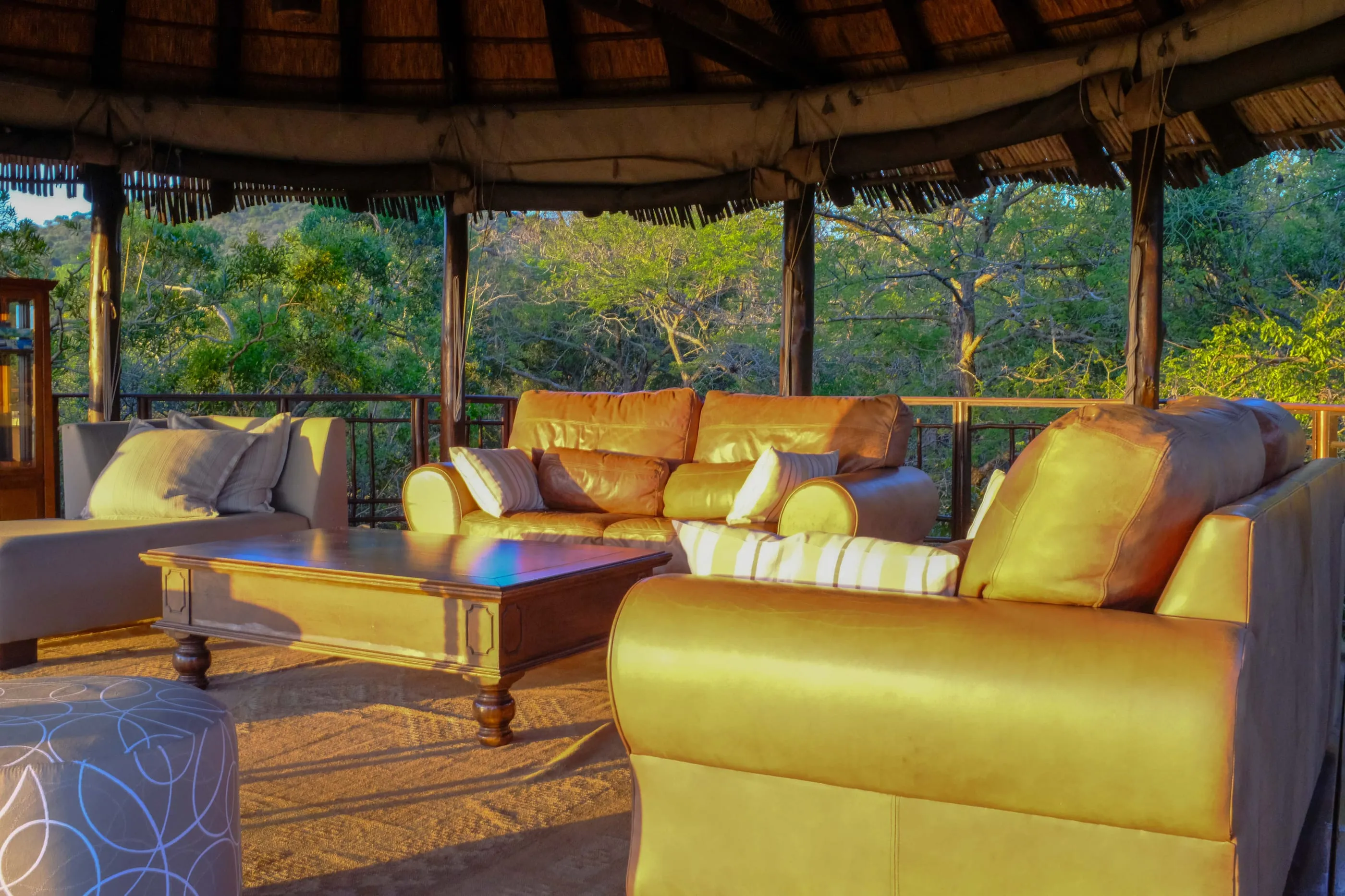 The lodge lounge, open to the bush under a thatched roof