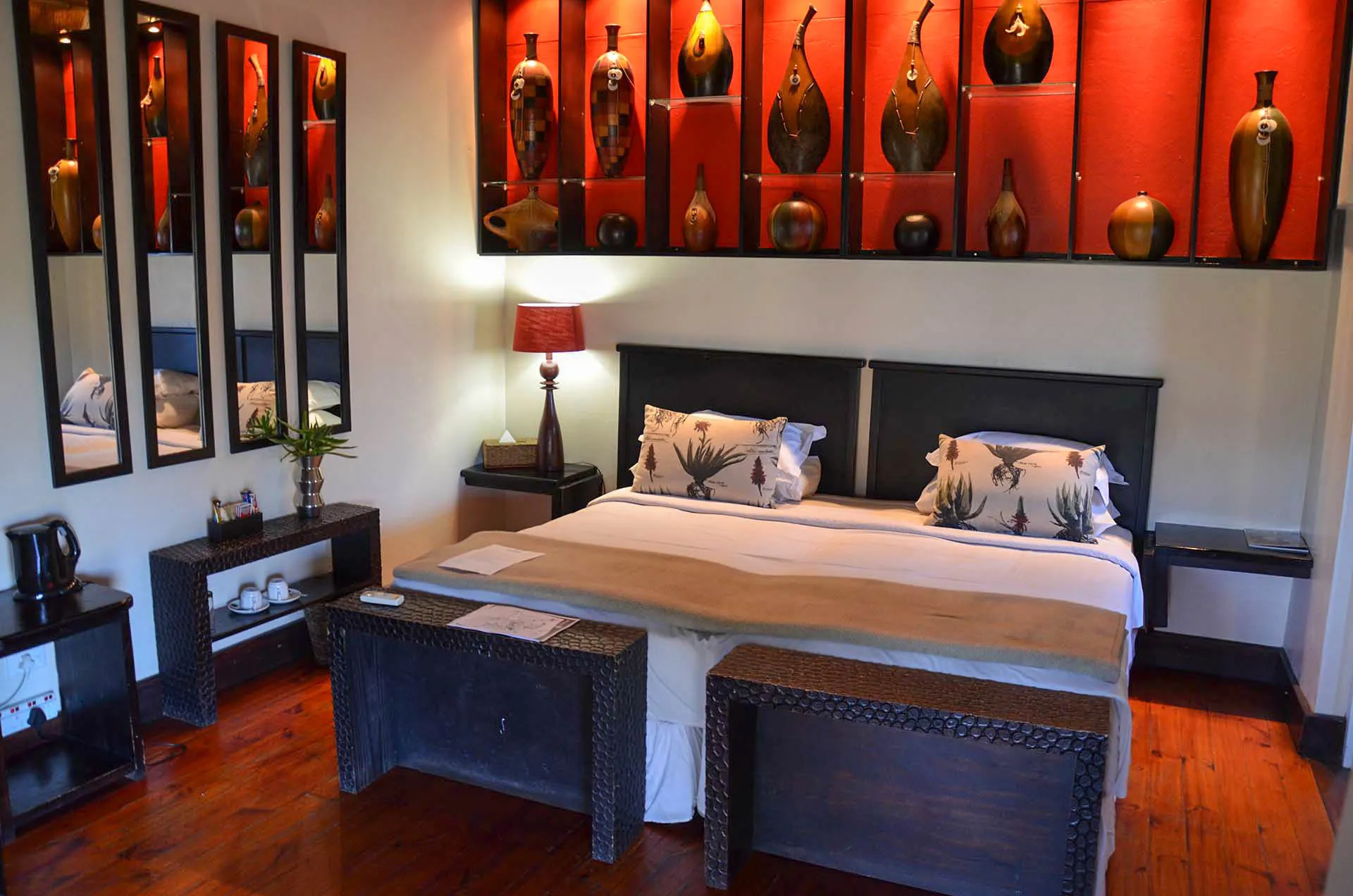The bedroom, simple and rustic against a deep red wall