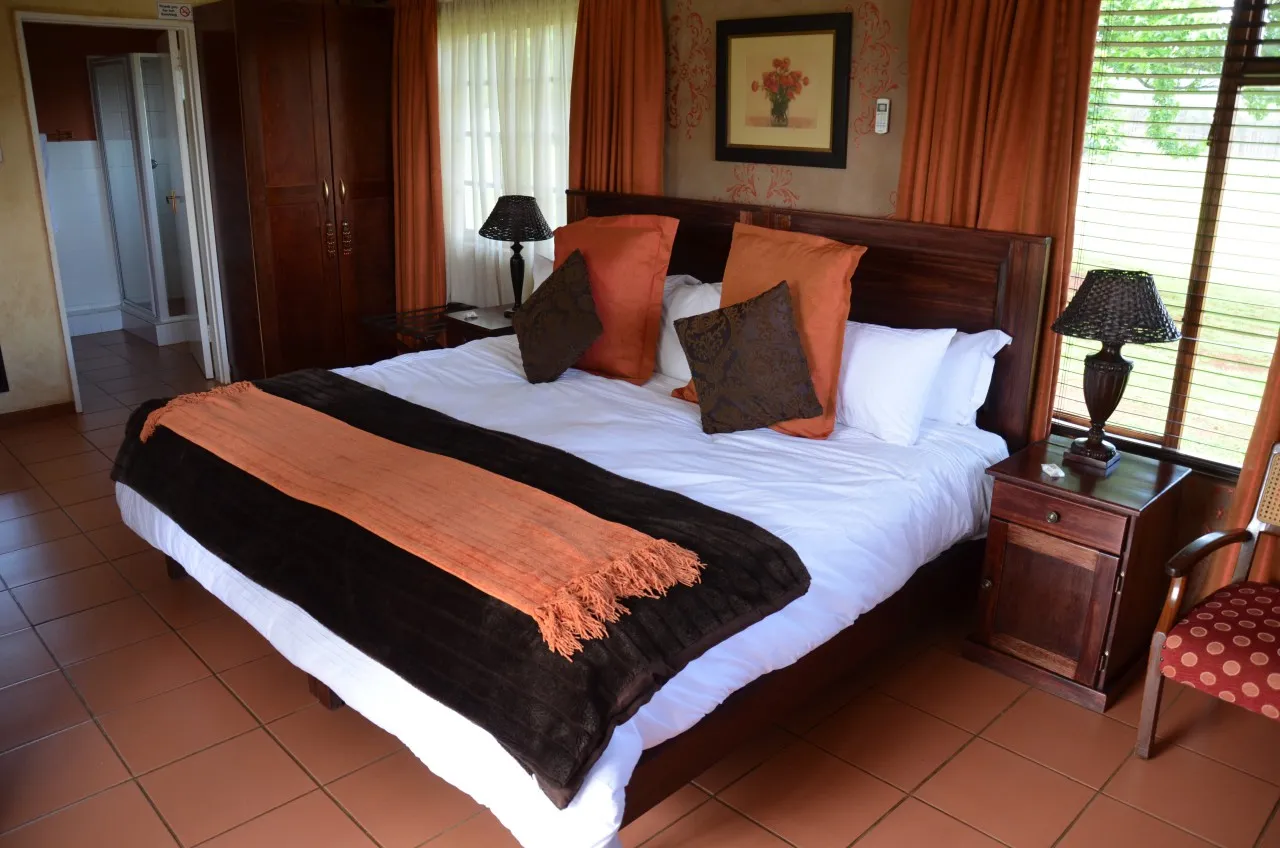 The bedroom seen from the doorway, curtains drawn back