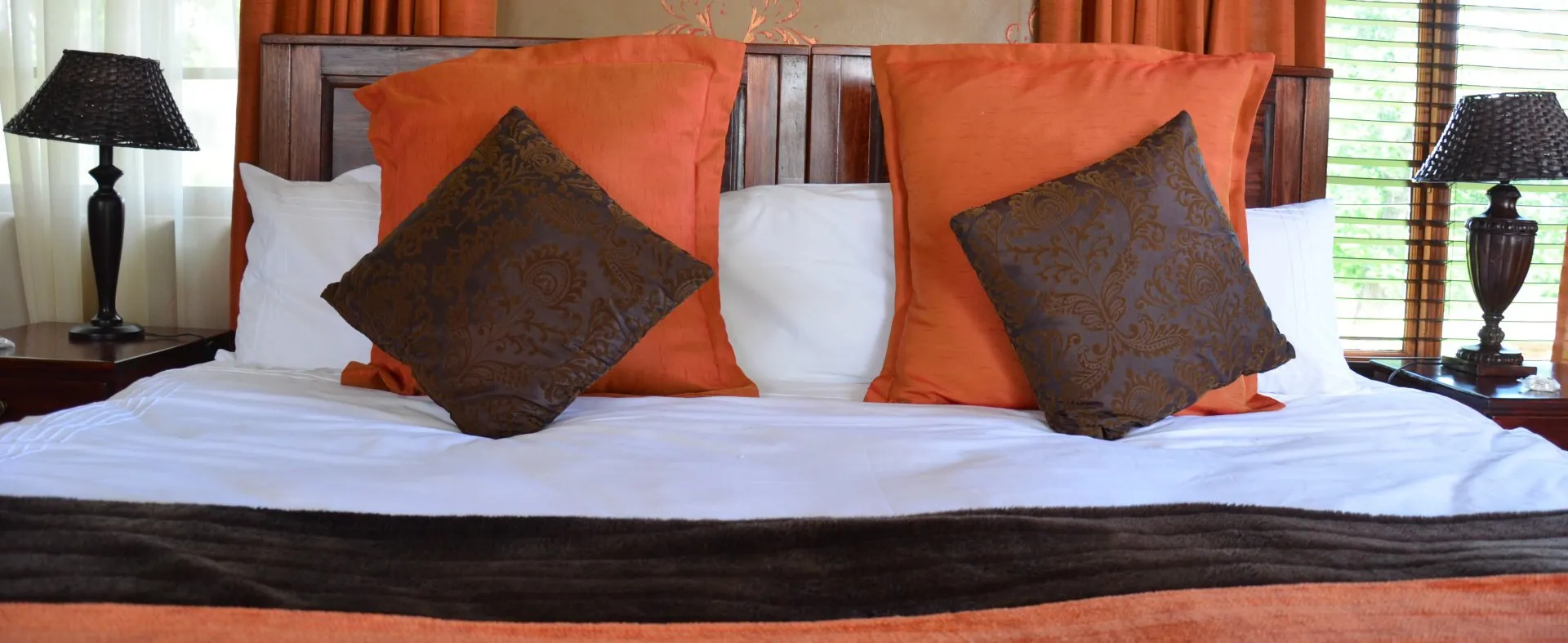 The bed made up with crisp linen and warm cushions