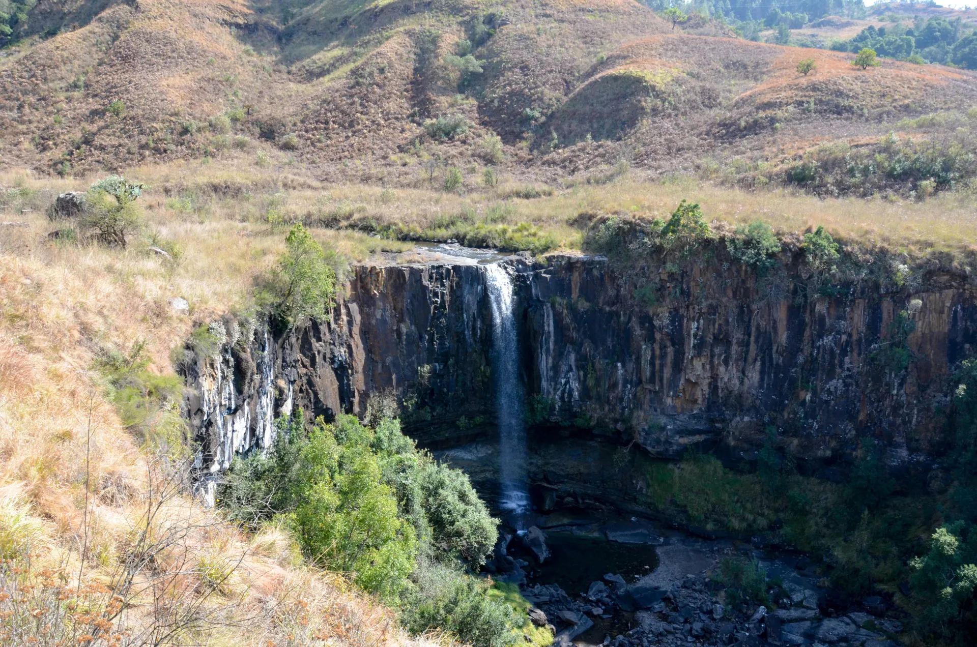 A waterfall dropping over a basalt lip into the pool below