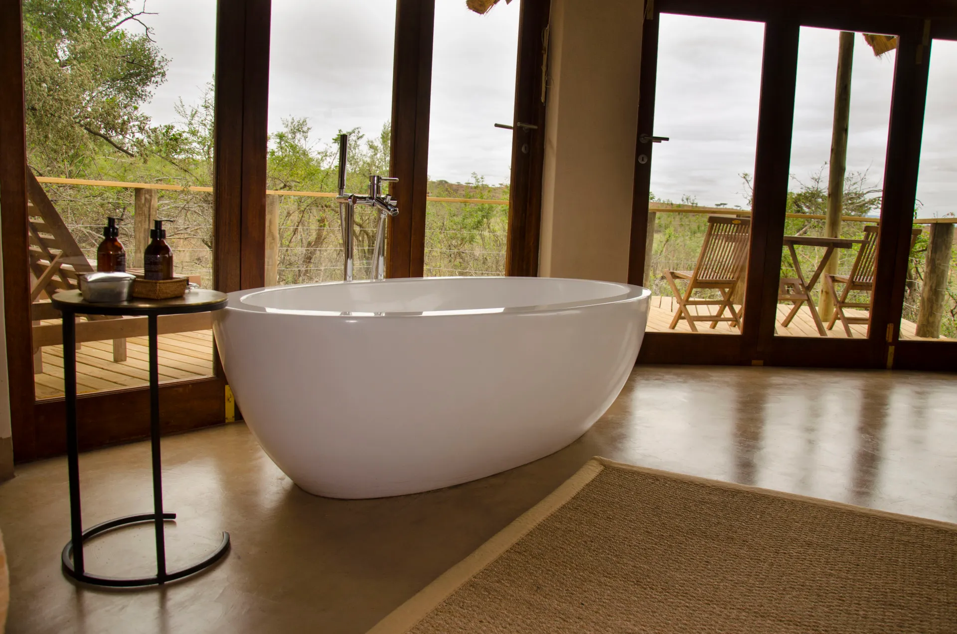 A freestanding bath set at a window looking out over the bush