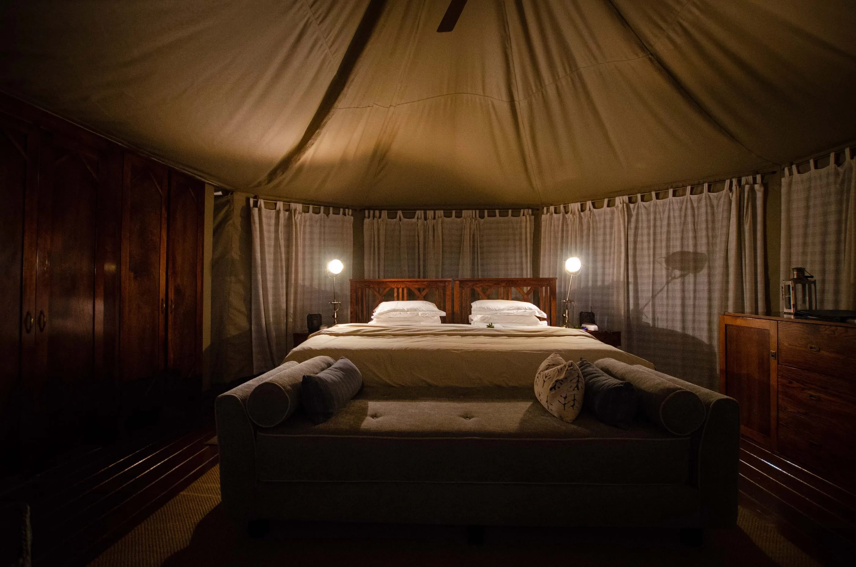 Inside a tent — king size bed and crisp white linen under canvas