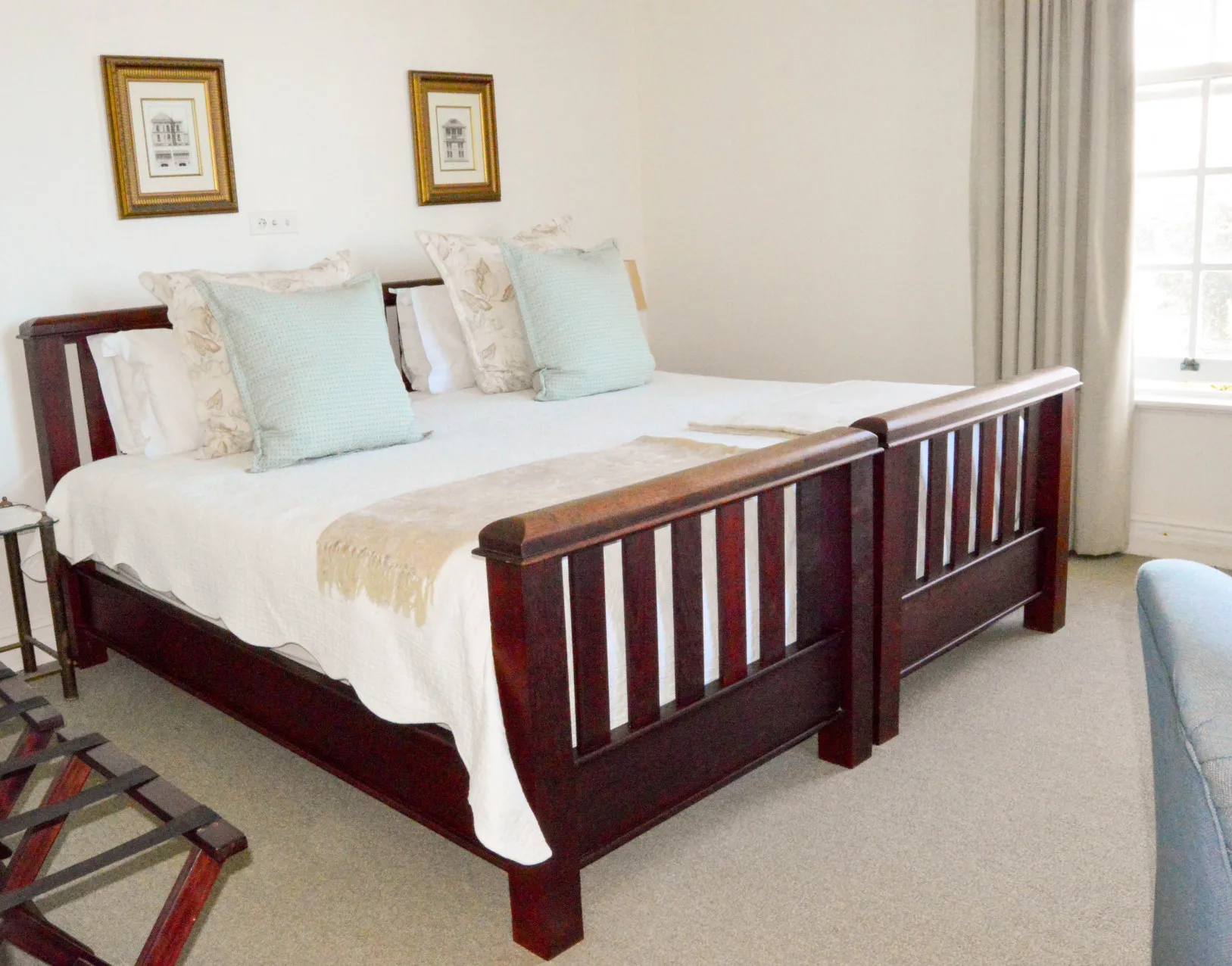 A bedroom with a dark wooden sleigh bed and pale linen