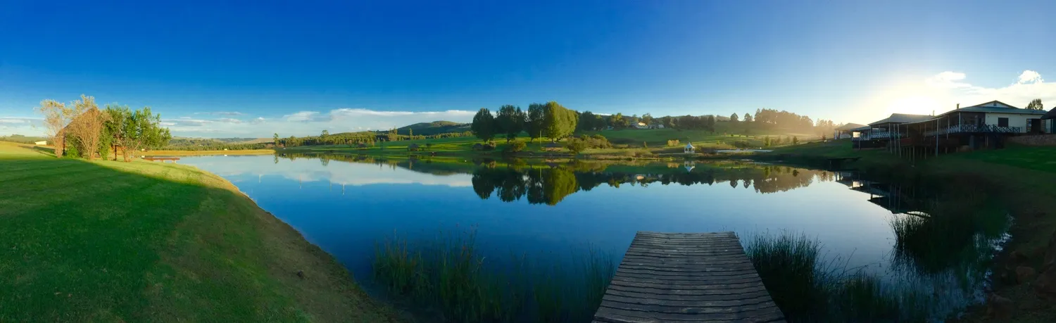 The lake at St Ives under a bright sky, jetty running out from the bank