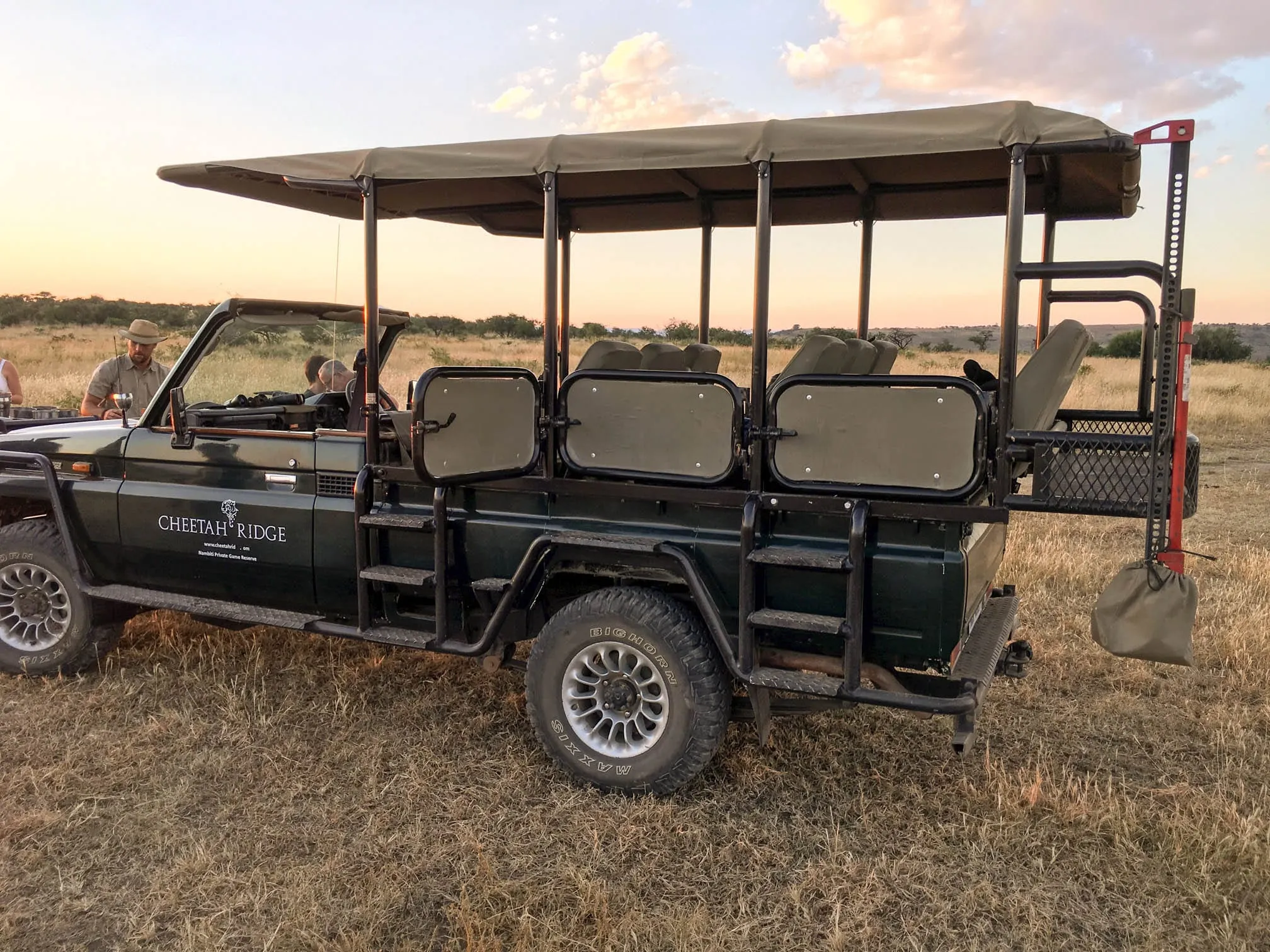 The open game drive vehicle parked and waiting on the grass