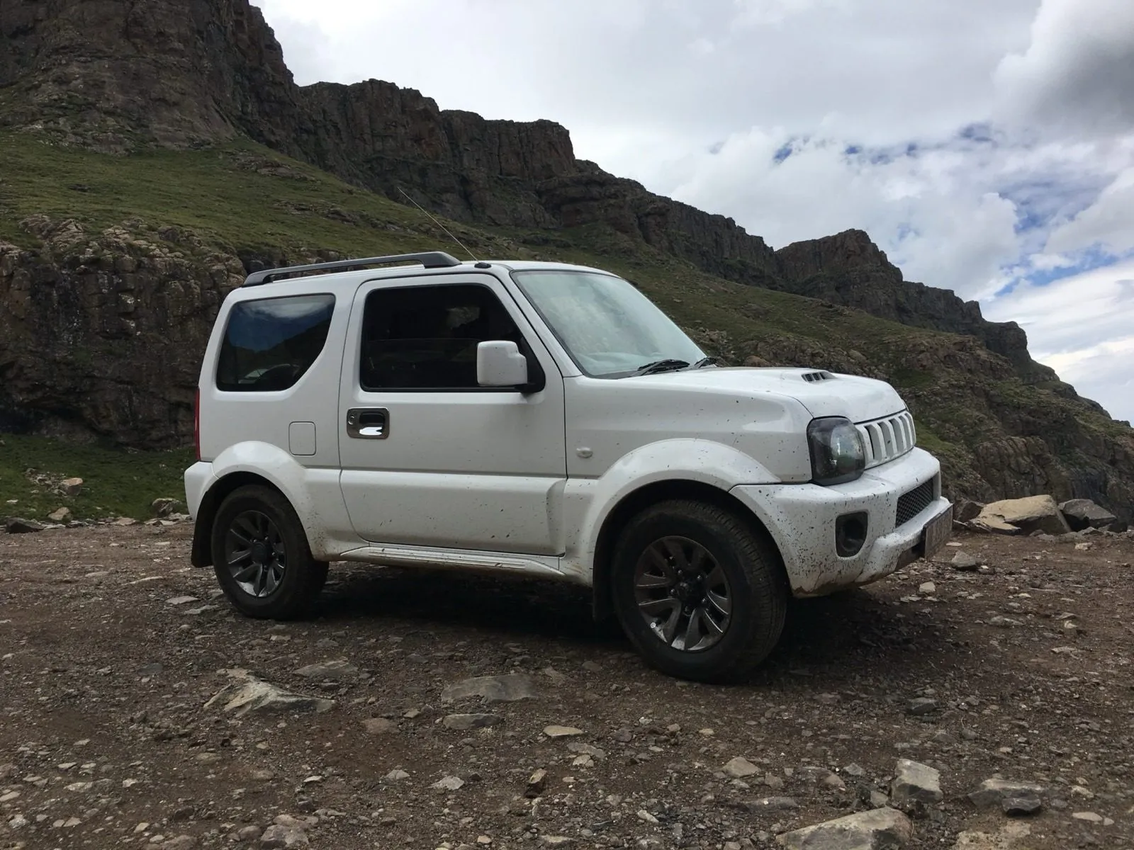 The Jimny parked below the cliffs