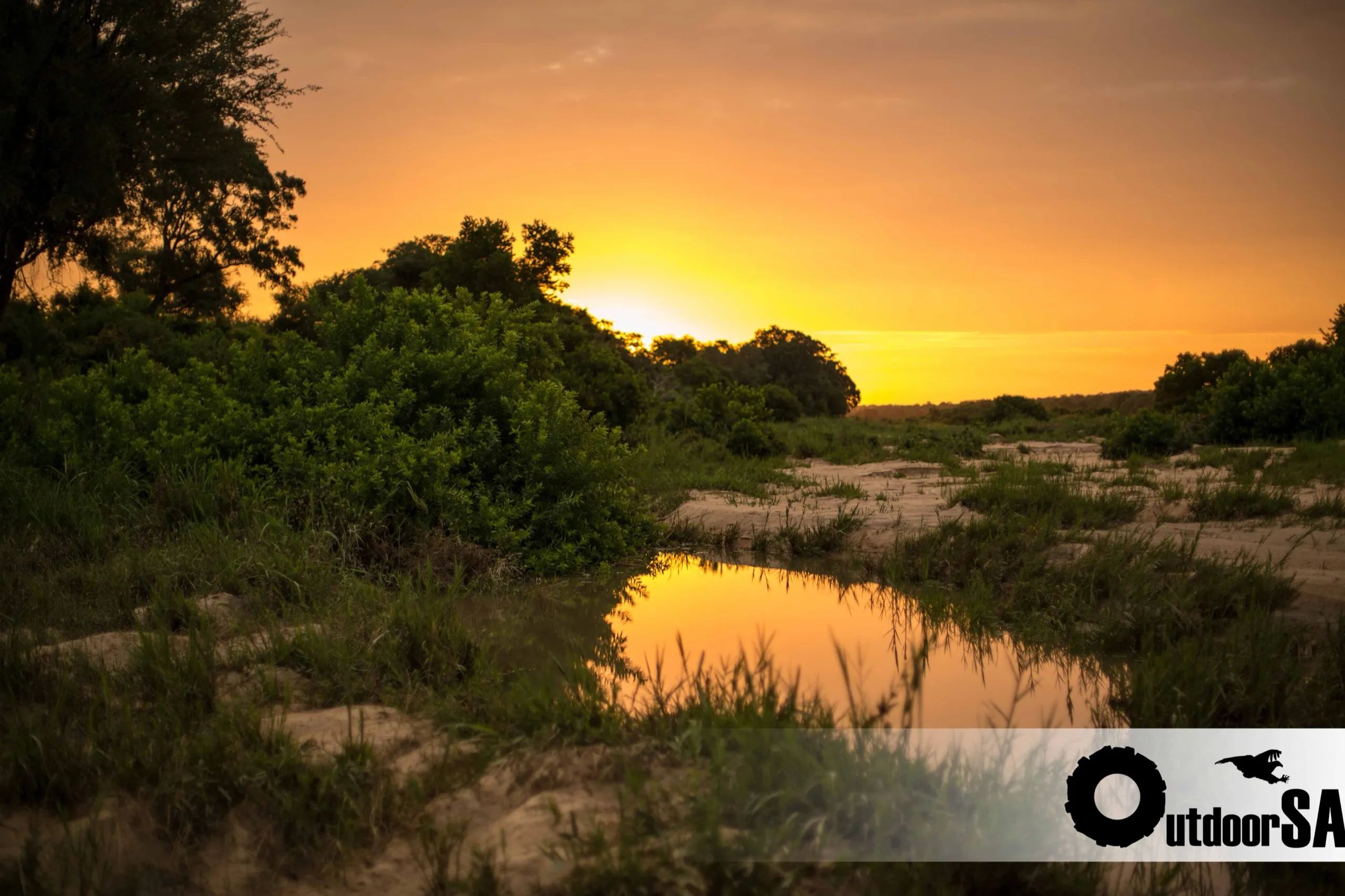 The sun going down over a bend in the Sand River