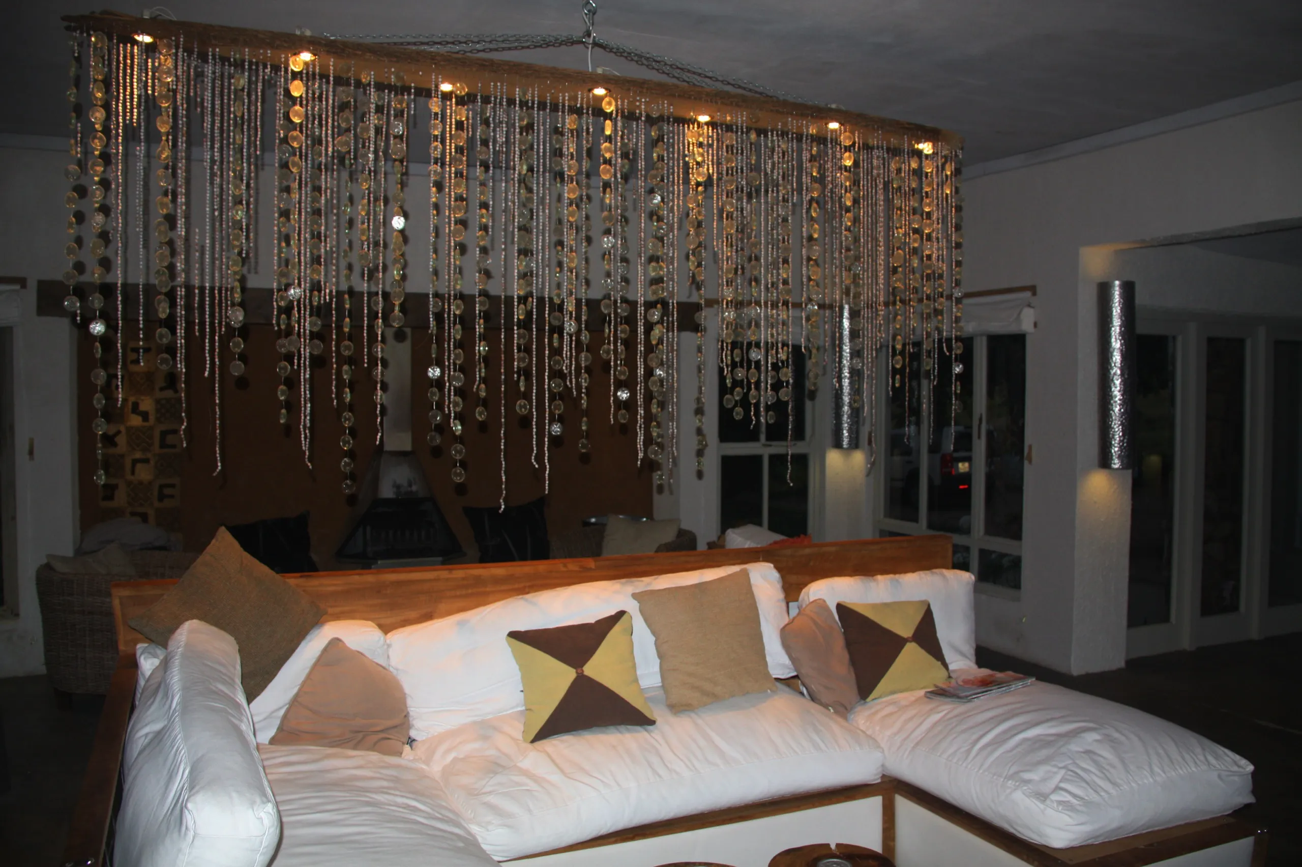 A sitting area strung with lights, white sofa and cushions