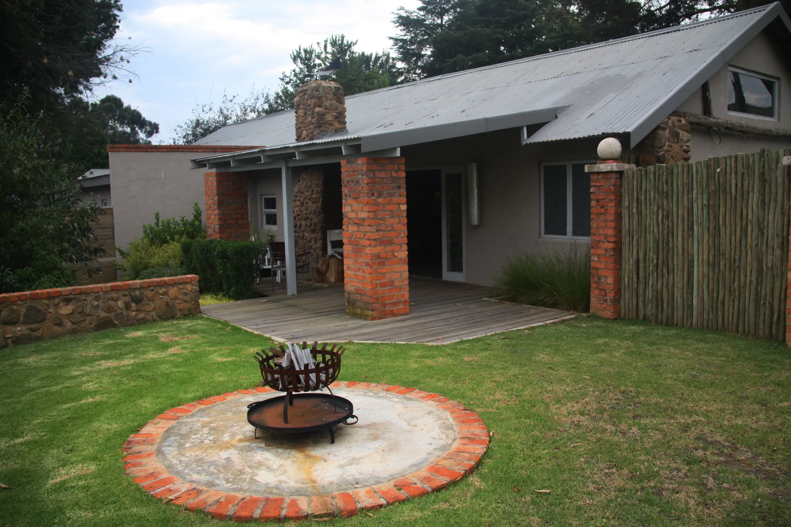 The lodge buildings behind a circular fire pit on the lawn