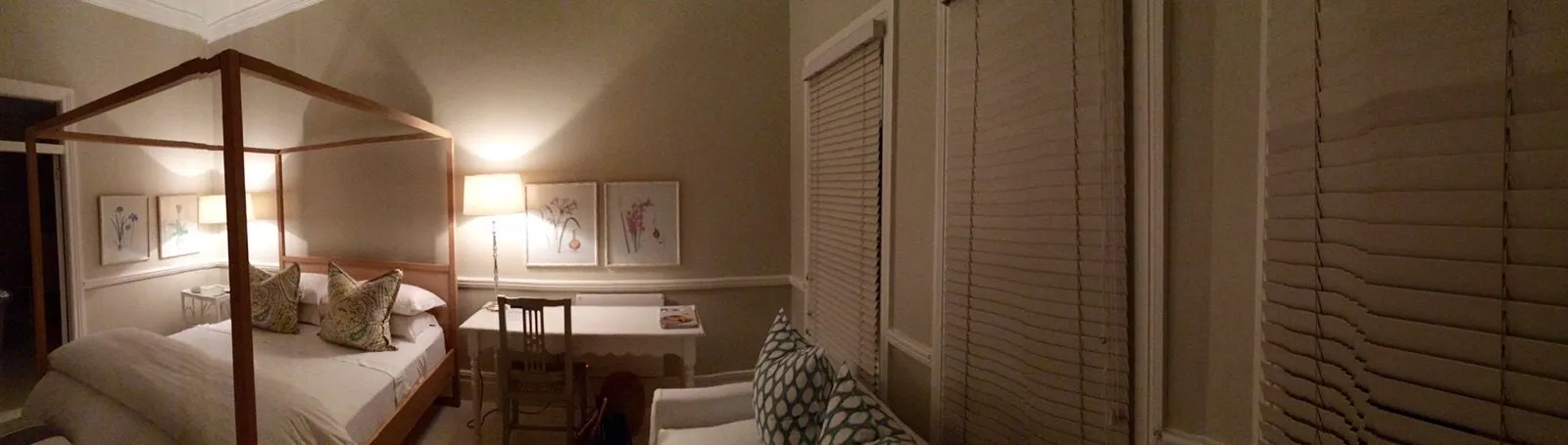 A bedroom with the lamps lit