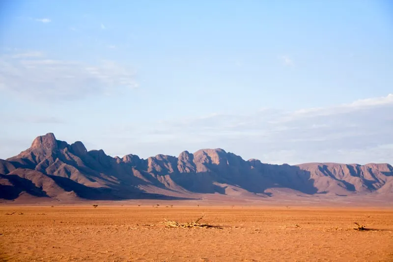 Jagged mountains rising from the desert plain in late afternoon light