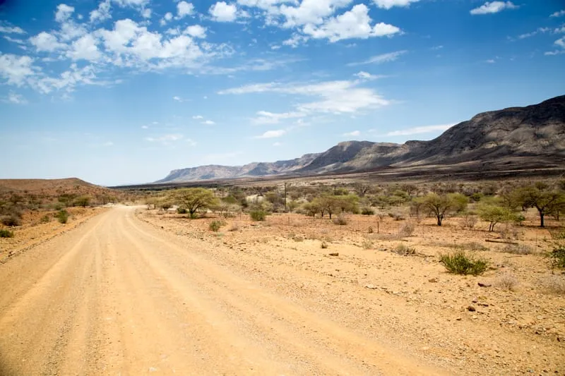 The gravel road running towards Sossusvlei between low hills