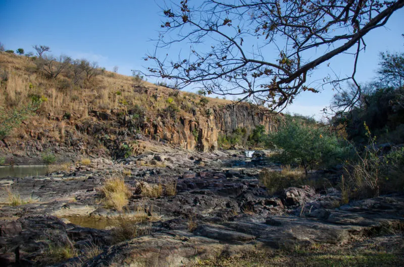 A rocky riverbed running below a low cliff on the reserve